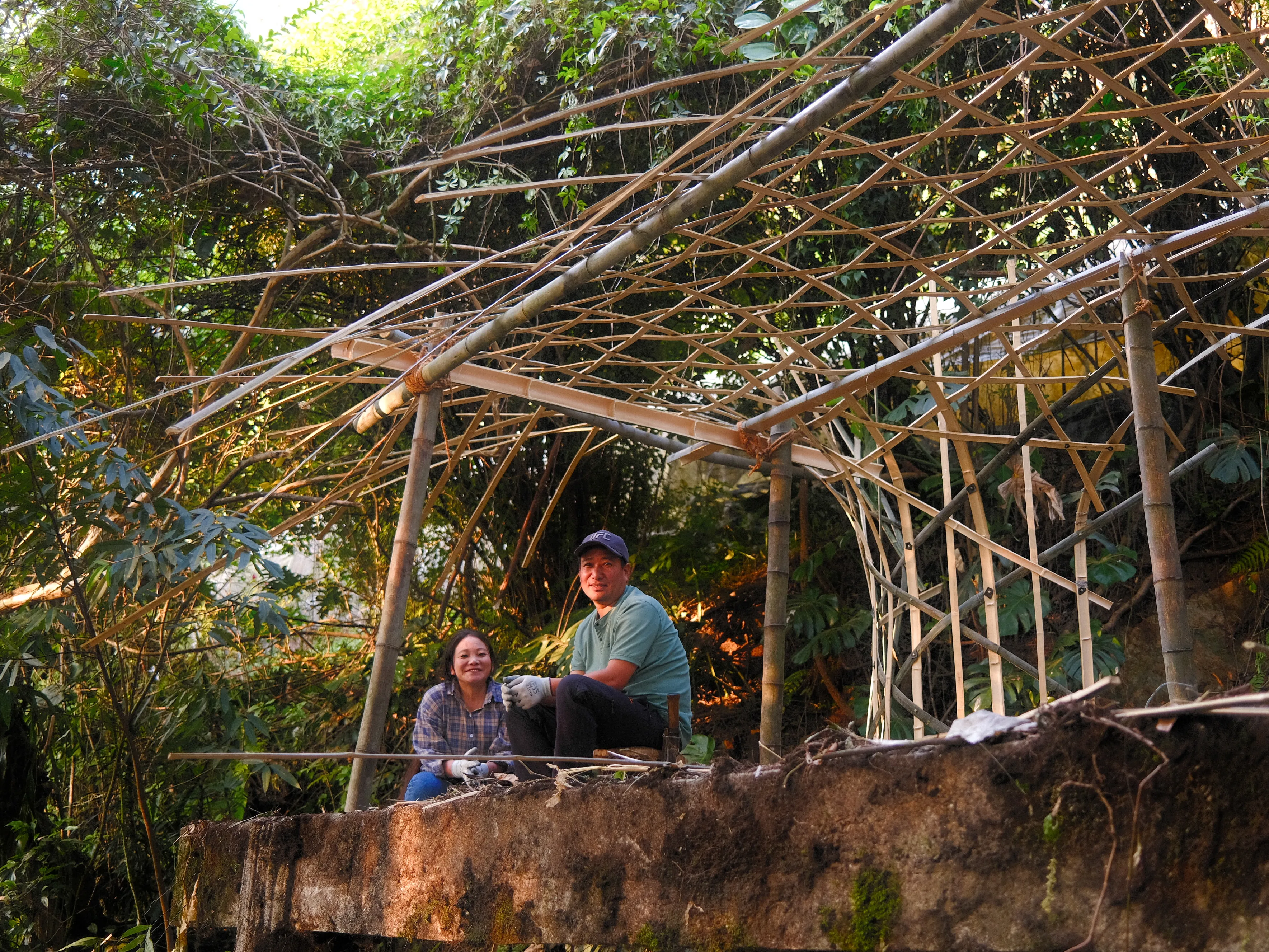 Palden and Nimmit standing in front of the partially completed bamboo pavilion