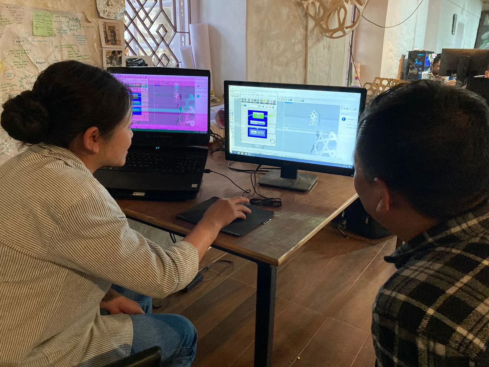 Palden and Nimmit using a computer to explore a bamboo weave